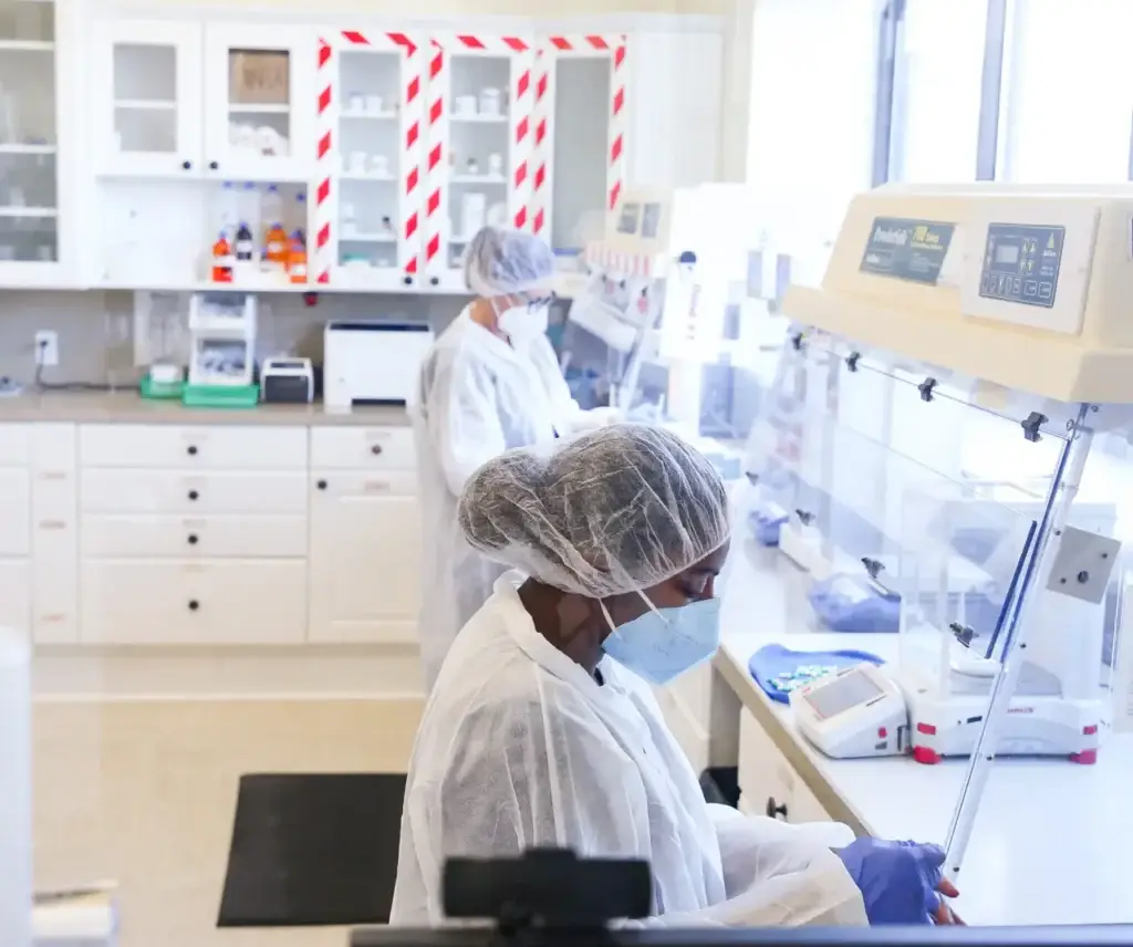 people in white coats and masks in a laboratory